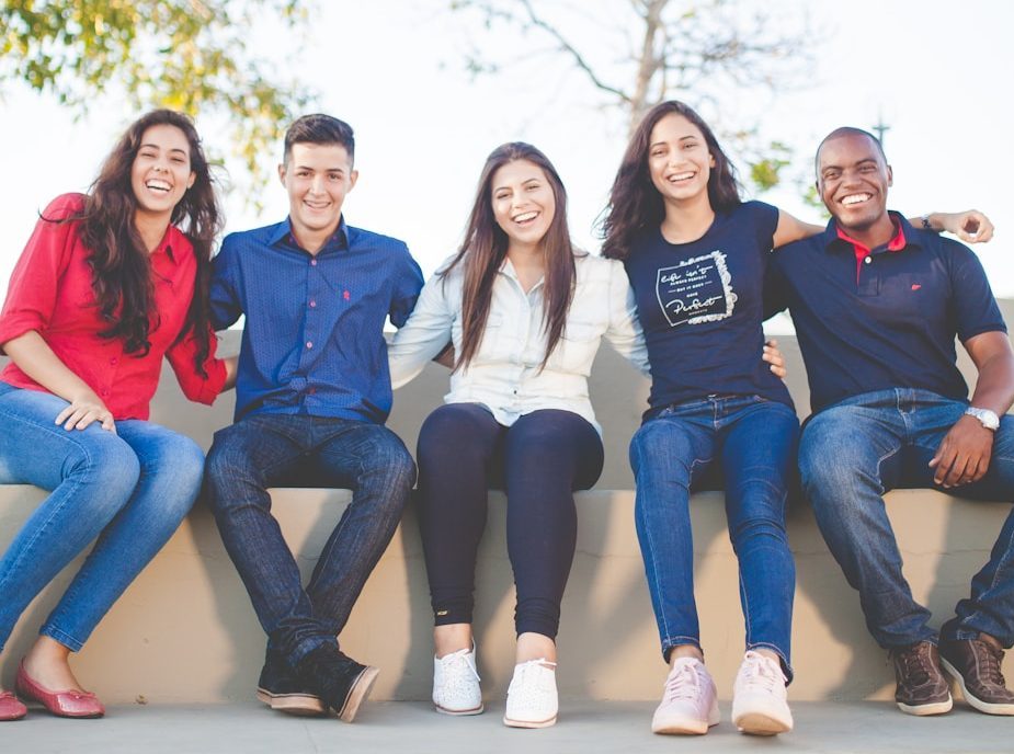 group of people sitting on bench near trees duting daytime