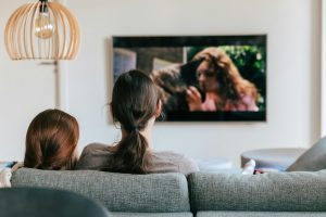 a couple of women sitting on top of a couch