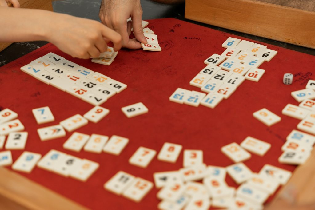 A person playing a game of dominos on a table